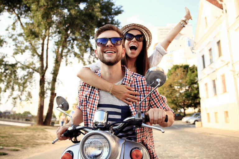 Couple in love riding a motorbike , Handsome guy and young sexy woman travel . Young riders enjoying themselves on trip. Adventure and vacations concept.